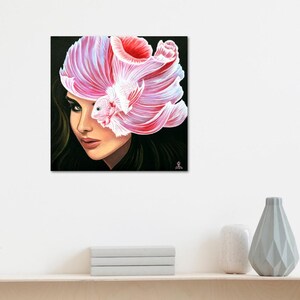 May include: A square canvas painting featuring a portrait of a person with dark hair, where a large, flowing pink and white betta fish is positioned over the right side of the face, obscuring the eye with its long, delicate, translucent fins.