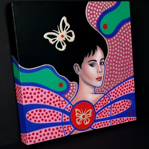 May include: A square canvas painting featuring a portrait of a person with dark hair against a black background. The composition includes vibrant green, blue, and pink dotted patterns, with two white butterfly motifs and a central red circle.