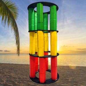 May include: A tower made of colorful blocks stacked in a circle. The tower is made of green, yellow, and red blocks. The tower is on a beach with a palm tree in the background.