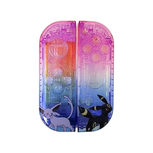 May include: A pair of transparent, colorful Nintendo Switch Joy-Con controllers. The controllers feature a gradient of colors, including pink, orange, blue, and purple. Each controller has a Pokemon character design, with Umbreon and Espeon graphics.