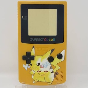 May include: Yellow Game Boy Color handheld video game console featuring a Pikachu design. The console has a black screen and the text "GAME BOY COLOR" is printed on the front.