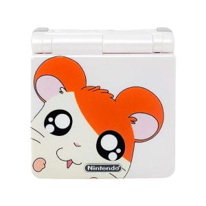 Op de afbeelding: Witte Nintendo DS Lite handheld-gameconsole met een cartoon-hamstergezicht aan de voorkant. De hamster heeft oranje vacht, grote zwarte ogen en een roze neus. Het Nintendo-logo is zichtbaar aan de onderkant van de console.