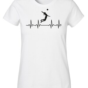 May include: White t-shirt with a black silhouette of a volleyball player spiking a ball, with a heartbeat graphic below.