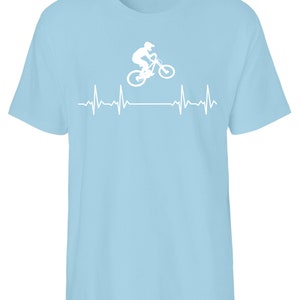 May include: A light blue t-shirt featuring a white silhouette of a person riding a mountain bike over a white heartbeat graphic.