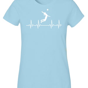 May include: Light blue t-shirt with a white silhouette of a volleyball player spiking a ball, with a white heartbeat line below.