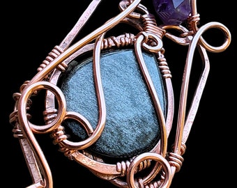 May include: A copper wire wrapped pendant featuring a dark green stone and a small purple amethyst stone.