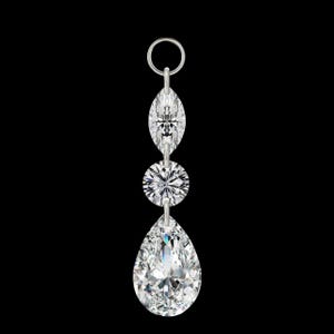 May include: A pendant featuring three clear, sparkling gemstones. The top stone is an oval shape, followed by a round stone, and a large pear-shaped stone at the bottom. The pendant hangs from a small silver ring against a black background.