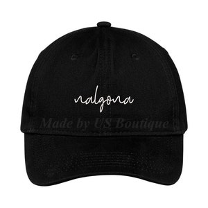 Op de afbeelding: Zwarte baseballpet met het witte woord "nalgona" in sierlijke letters op de voorkant. De tekst "Made by US Boutique" is eronder gedrukt. De pet heeft een gebogen klep en een verstelbare band.