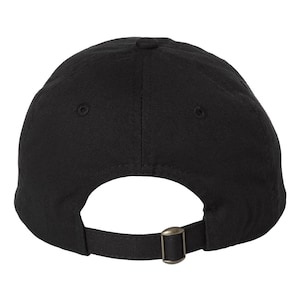 The back side of a baseball hat showing and adjustable strap and buckle.