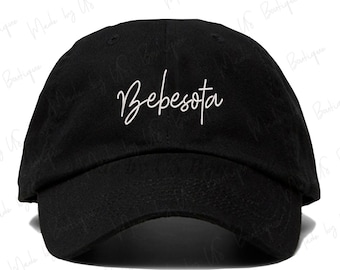 Puede incluir: Gorra de béisbol negra con la palabra "Bebesota" en escritura blanca en la parte delantera. La gorra tiene una visera curva y un diseño clásico de seis paneles. Un accesorio elegante para uso casual.