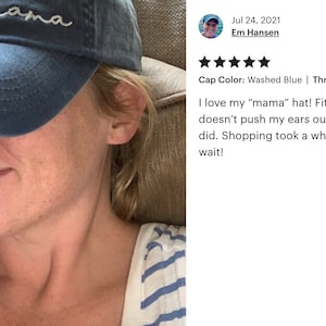 May include: Washed blue baseball cap with the word "mama" embroidered in white script. The hat is a classic six-panel design with a curved brim, perfect for casual wear.