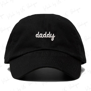 May include: Black baseball cap with a white embroidered word "daddy" on the front.