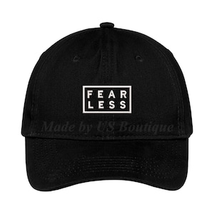 May include: Black baseball cap with a white box that says "FEARLESS" on it.