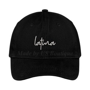 May include: A black baseball cap with a white cursive inscription that reads "latina".