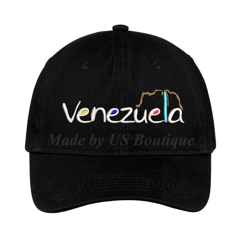 May include: Black baseball cap with white embroidery that reads "Venezuela" and "Made by US Boutique". The word "Venezuela" is outlined with a brown, yellow, blue, and red outline.