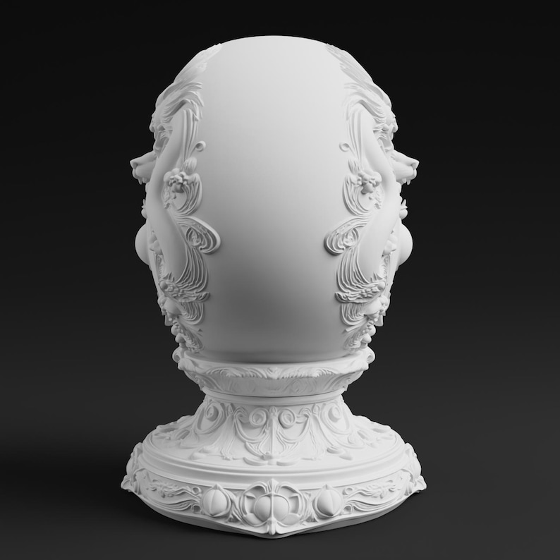 Peut inclure: Une sculpture en forme d'&oelig;uf blanc mat pr&eacute;sentant des reliefs complexes de motifs floraux et de volutes. L'objet repose sur une large base pi&eacute;destal orn&eacute;e avec des motifs d&eacute;coratifs d&eacute;taill&eacute;s, offrant une surface lisse et solide.