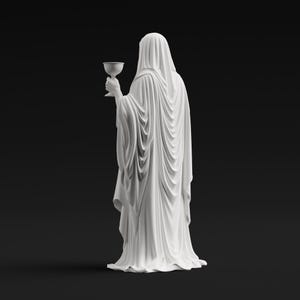 May include: A white statue of a figure draped in a long, flowing hooded robe, viewed from behind. The figure holds a small, stemmed chalice in one hand. The sculpture features intricate, deep folds in the fabric that cascade down to the base.