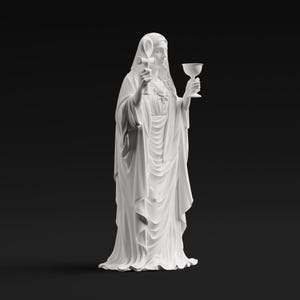May include: A matte white statue of a figure draped in flowing robes, holding an ankh symbol in the right hand and a chalice in the left hand. The figure has long hair and a veil, with a heart emblem visible on the chest area of the garment.