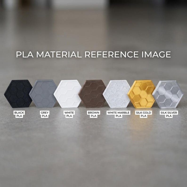 May include: A PLA material reference image featuring seven hexagonal tiles in a row. The colors are labeled as black, grey, white, brown, white marble, silk gold, and silk silver. Each tile displays a raised honeycomb pattern on its surface.