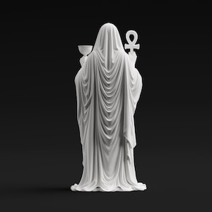 May include: A white statue of a cloaked figure viewed from behind, draped in flowing fabric that falls to the base. The figure holds a chalice in the right hand and an ankh symbol in the left hand, with the hood covering the head completely.