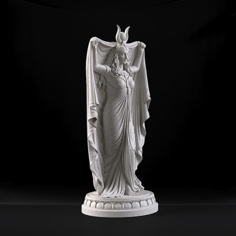 Peut inclure: Une statue en pierre gris clair repr&eacute;sentant une silhouette debout v&ecirc;tue d'une longue robe fluide et d'une coiffe orn&eacute;e d'un croissant de lune et d'un disque solaire. La silhouette tient un grand drap&eacute; au-dessus de sa t&ecirc;te, pos&eacute;e sur un socle.