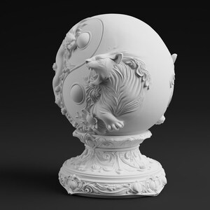 Peut inclure: Une sculpture sph&eacute;rique blanc mat pr&eacute;sentant un relief de tigre rugissant int&eacute;gr&eacute; dans un motif de symbole yin-yang. L'objet repose sur une base pi&eacute;destal circulaire et orn&eacute;e, d&eacute;cor&eacute;e de sculptures complexes de fleurs et de volutes.