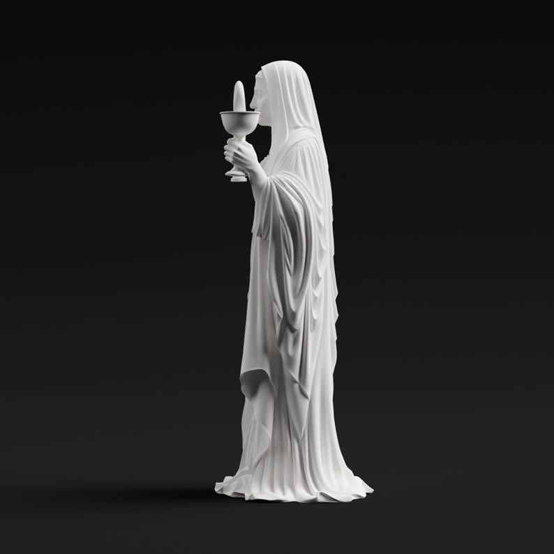 May include: A white matte statue of a figure draped in long, flowing robes, standing in profile. The figure holds a chalice with a small, upright cylindrical object inside. The sculpture features detailed folds in the fabric and a smooth finish.