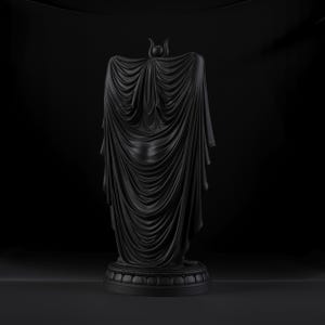 Peut inclure: Une sculpture noir mat repr&eacute;sentant une silhouette drap&eacute;e dans une longue cape fluide aux plis complexes. La figure pr&eacute;sente une petite coiffe en forme de croissant au sommet et repose sur une base circulaire &agrave; gradins avec un motif de p&eacute;tales.