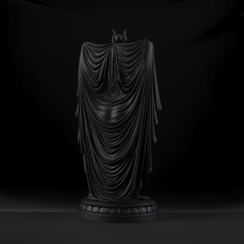 Peut inclure: Une sculpture noir mat repr&eacute;sentant une silhouette drap&eacute;e dans une longue cape fluide aux plis complexes. La figure pr&eacute;sente une petite coiffe en forme de croissant au sommet et repose sur une base circulaire &agrave; gradins avec un motif de p&eacute;tales.