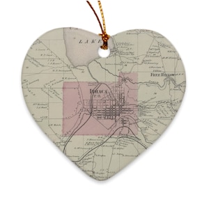 May include: A vintage map of Ithaca, New York, printed on a heart-shaped ornament. The map shows the city's streets, buildings, and surrounding areas. The map is in shades of brown, pink, and black.