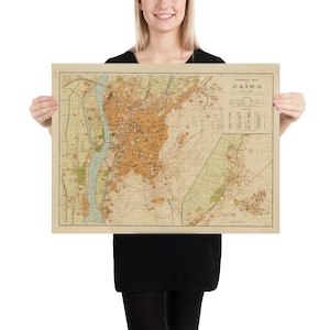 May include: A vintage map of Cairo, Egypt, printed on a beige background. The map shows the city's streets, landmarks, and the Nile River. The title "General Map of Cairo" is printed in the upper right corner.