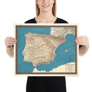 May include: A vintage map of Spain and Portugal, printed on paper with a blue background and brown borders. The map shows the countries' geographical features, including mountains, rivers, and coastlines. The map is titled "Spain and Portugal" and includes a key with various symbols.