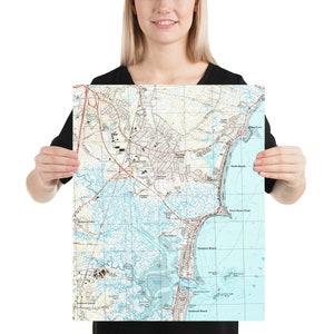 May include: A vintage-style map of Hampton, Virginia, showing the town and surrounding coastal areas. The map is printed on white paper with blue and brown lines and text. The map is framed and ready to hang.