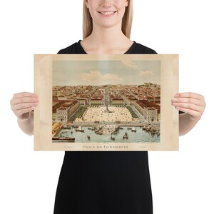 May include: A vintage print of Pra&ccedil;a do Com&eacute;rcio in Lisbon, Portugal. The print depicts a detailed aerial view of the square, buildings, and harbor with boats. The print has a sepia tone and the text "Pra&ccedil;a do Com&eacute;rcio" is visible.