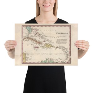 May include: An antique map of the West Indies, showing the islands of the Caribbean Sea. The map is printed on aged paper with a light brown background and features a variety of colors, including green, blue, red, and yellow. The map is titled "West Indies" and includes a key with various symbols and labels.
