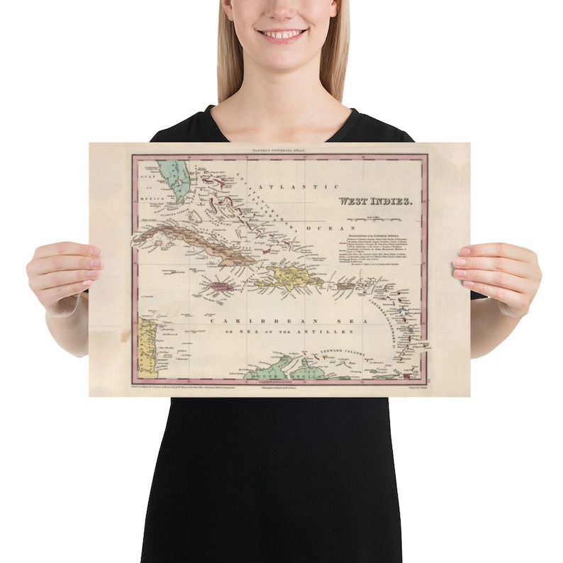 May include: An antique map of the West Indies, showing the islands of the Caribbean Sea. The map is printed on aged paper with a light brown background and features a variety of colors, including green, blue, red, and yellow. The map is titled "West Indies" and includes a key with various symbols and labels.