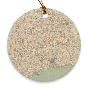 Peut inclure: Une carte vintage du Connecticut, imprimée sur une décoration ronde en céramique. La carte montre les comtés de l'État et les routes principales. La décoration est de couleur brun clair avec une bordure verte.