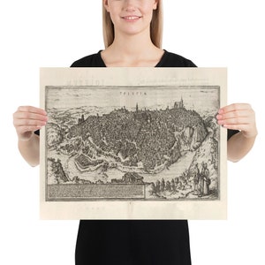 Puede incluir: Un mapa vintage en blanco y negro de Toledo, Espa&ntilde;a. El mapa muestra el dise&ntilde;o de la ciudad y el paisaje circundante. El t&iacute;tulo "TOLETTVM" est&aacute; impreso en la parte superior del mapa.