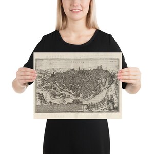 Puede incluir: Un mapa vintage en blanco y negro de la ciudad de "T&uuml;bingen" de 1577. El mapa muestra la disposici&oacute;n de la ciudad con sus calles, edificios y el paisaje circundante. El mapa est&aacute; impreso en papel de color crema.
