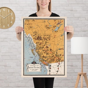 May include: A vintage map of British Columbia, Canada, with an animated design. The map has a tan background with detailed illustrations and text, including the title "Animated Map of British Columbia". The map is framed in a light-coloured wooden frame.