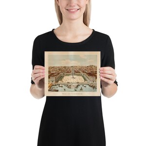 May include: A vintage print of Pra&ccedil;a do Commercio, a historic square in Lisbon, Portugal. The print features a detailed illustration of the square, with buildings, boats, and people. The print is held by a person.