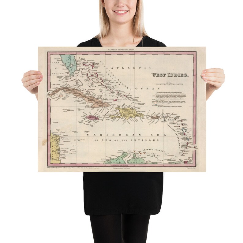 May include: An antique map of the West Indies, showing the islands of the Caribbean Sea. The map is printed in black, red, green, and yellow on a white background. The map is titled "West Indies" and includes the text "Caribbean Sea or Sea of the Antilles".