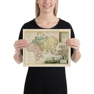 May include: A vintage world map print featuring a detailed illustration of the continents in shades of green, yellow, and pink. The map has a decorative border and a small tree in the bottom right corner.