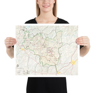 May include: A detailed map of Mammoth Cave National Park, featuring roads, trails, and points of interest. The map uses a color-coded system to distinguish between different features, with green representing park boundaries and brown for roads.
