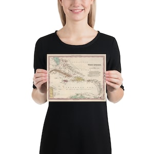 May include: A vintage map of the West Indies, showing the islands and surrounding waters. The map is printed in shades of brown, green, and red, with text labels in black. The title "West Indies" is printed in the upper right corner.