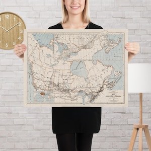 Op de afbeelding: Een vintage kaart van Canada, met gedetailleerde geografische informatie en gelabelde regio's. De kaart is gedrukt op verouderd papier met een lichtblauw en beige kleurenschema. De titel "Dominion of Canada" is zichtbaar.
