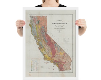 Op de afbeelding: Een vintage kaart van de staat Californië, die de geologische formaties en minerale afzettingen laat zien. De kaart is gedrukt in verschillende kleuren, waaronder rood, geel, groen en blauw. De kaart is ingelijst in een wit frame.