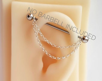 May include: A silver chain with two strands hangs from a silver barbell piercing. The barbell is inserted into a fake earlobe. The text "NO BARBELL INCLUDED" is printed on the background.