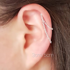 May include: Silver chain ear cuff with two chains hanging down. The ear cuff is 3cm/5cm long.