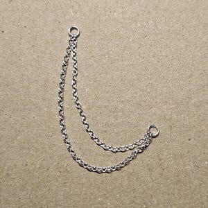 May include: A silver chain necklace with two strands and a circular clasp at each end.